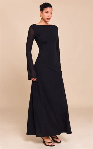 A sophisticated black chiffon maxi dress with a high neckline, sheer long sleeves, and flowing layers, styled with embellished heels and a clutch.