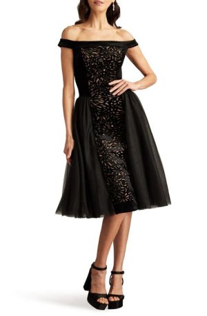Chic black off-the-shoulder cocktail dress, ideal for adding a touch of sultry elegance to a winter wedding outfit.