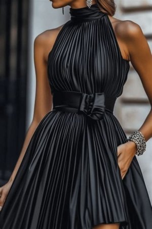 A stylish black pleated midi dress featuring metallic accents, a high neckline, and cinched waist, accessorized with strappy heels and simple earrings.